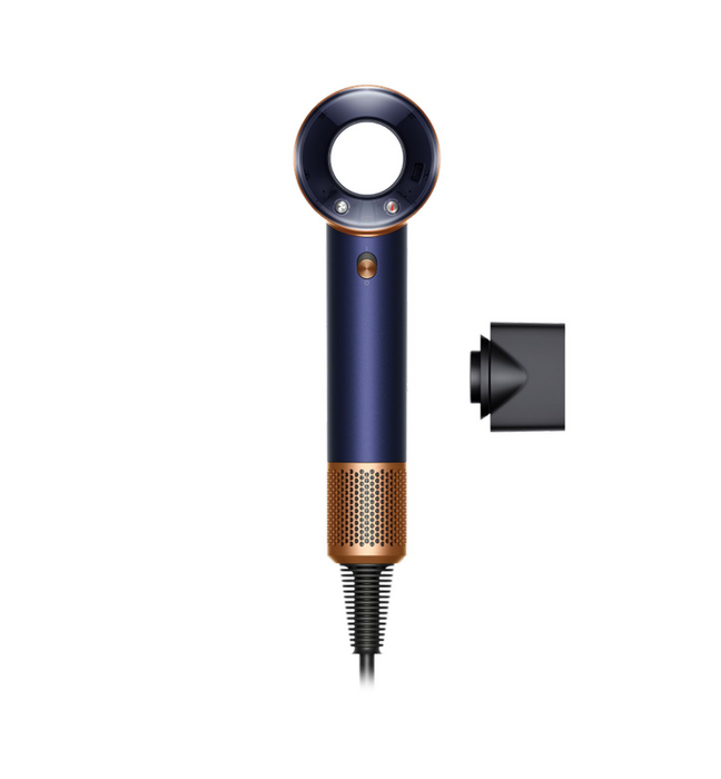 A cordless hair dryer in a dark navy blue and rose gold colorway, shown with its black concentrator nozzle attachment against a solid white background.