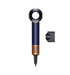A cordless hair dryer in a dark navy blue and rose gold colorway, shown with its black concentrator nozzle attachment against a solid white background.