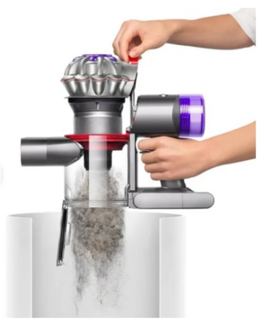 A cordless vacuum cleaner with a transparent dust bin and purple and silver body, shown with a person's hands demonstrating how to empty it into a white container against a white background.


