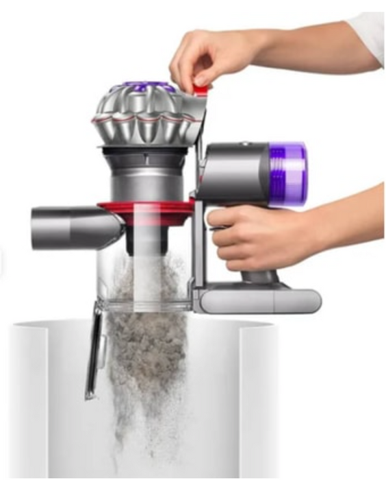 A cordless vacuum cleaner with a transparent dust bin and purple and silver body, shown with a person's hands demonstrating how to empty it into a white container against a white background.

