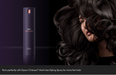 A tall matte black Dyson Chitosan Multi-Use Styling Spray bottle stands against a dark studio background beside a close-up of a woman with voluminous dark hair, with text at the bottom mentioning pairing with the spray for twice the hold.